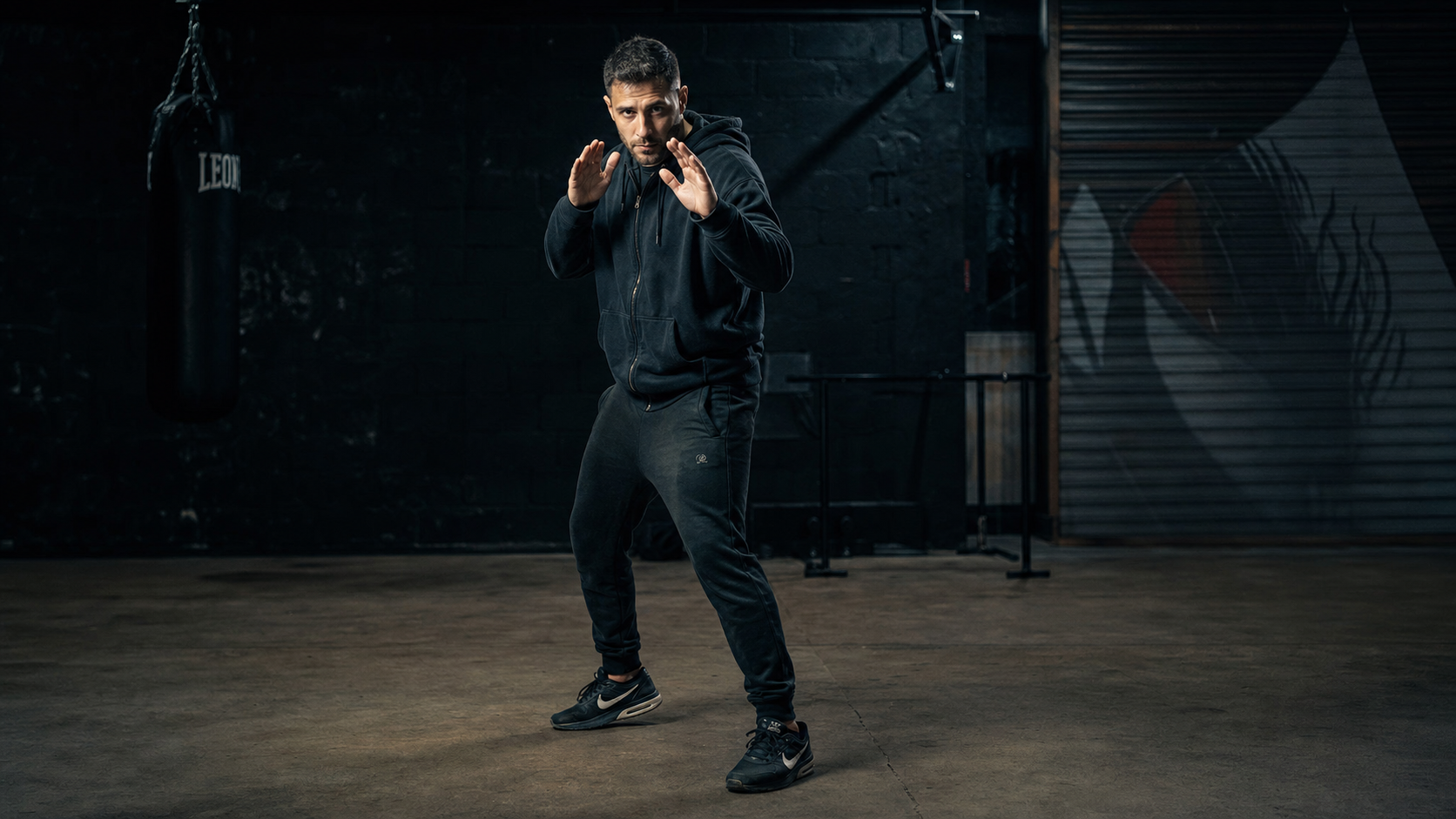 Defensive fighting stance in dark gym